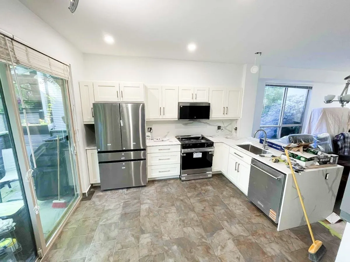 Modern kitchen with new white cabinets and stainless steel appliances